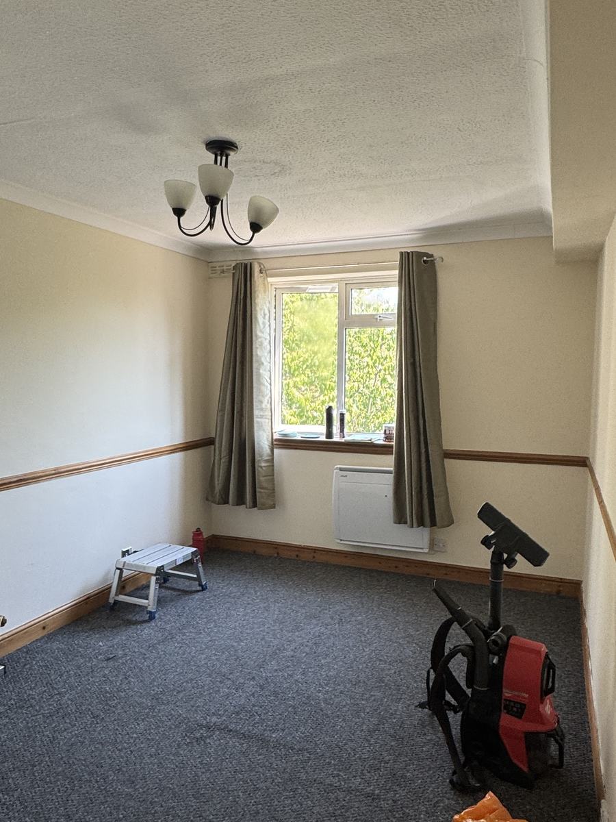 Bedroom before: cream walls, wooden dado rail and skirting