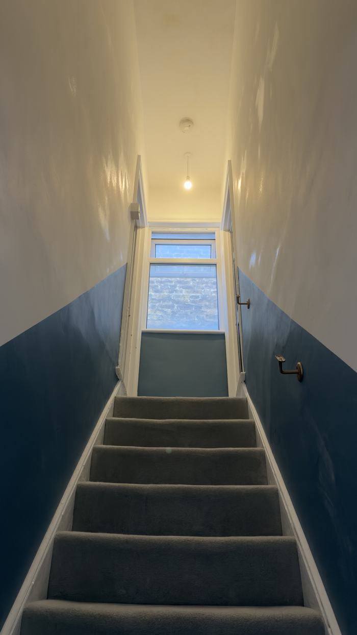 Narrow stairwell, cream above and blue below