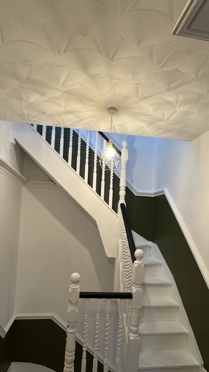 Staircase with textured white ceiling and dark green walls