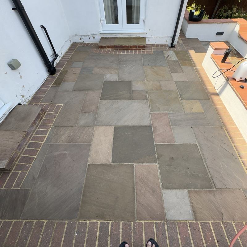 Cleaned sandstone patio with brick border