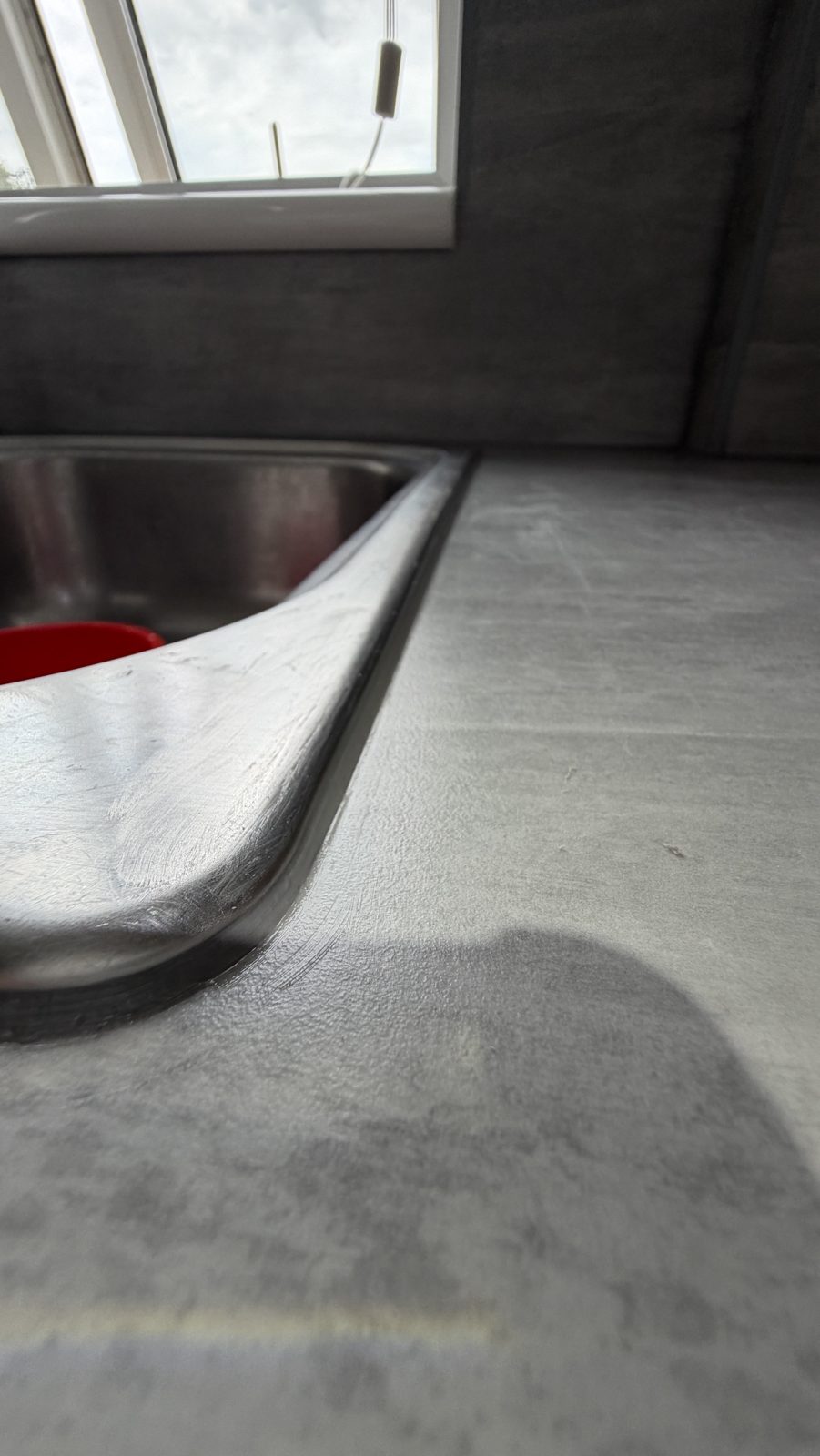 Close-up of a clean new silicone bead around a kitchen sink rim