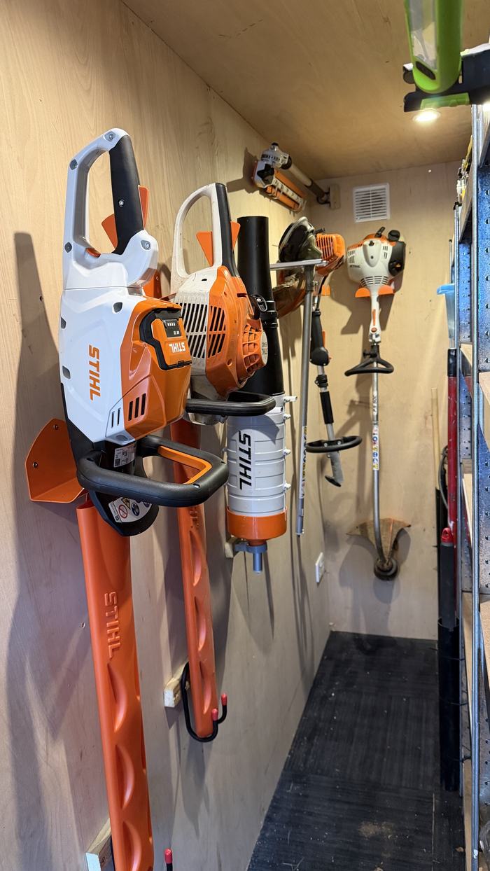 Garden power tools hung on wall brackets