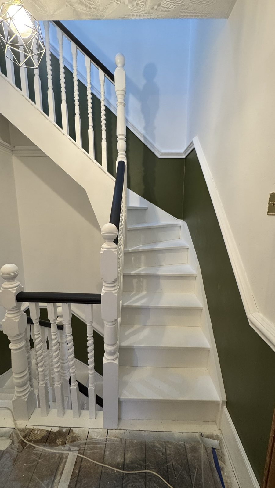 Victorian staircase in Addiscombe after painting: white spindles and treads, dark handrail, deep green walls below the dado
