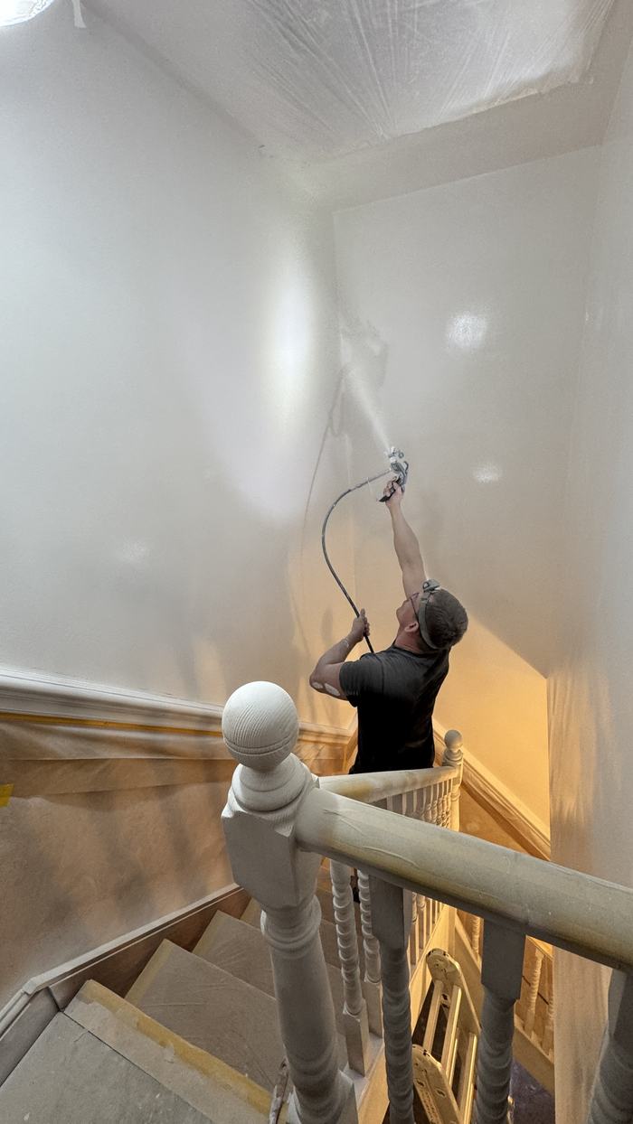 Alex spraying paint onto a stairwell wall