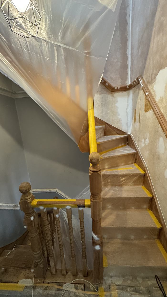 Staircase sheeted in plastic with masking tape on the treads